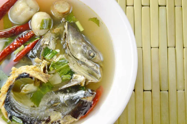 Cozido fumado peixe cabeça de cobra seca em sopa picante e azeda na tigela — Fotografia de Stock