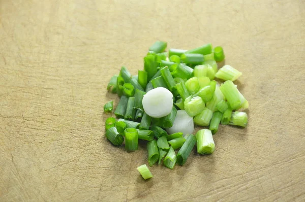 Spring onion slice on wooden chop block — Stock Photo, Image