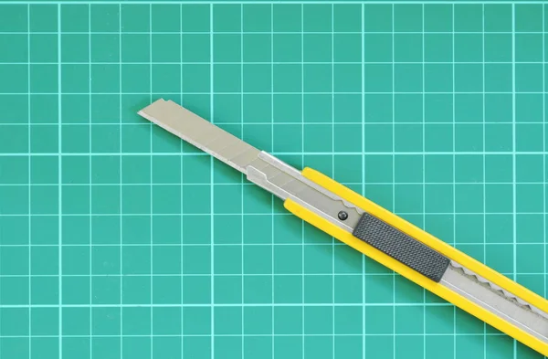 Cutter geopend mes en groene snijmat — Stockfoto