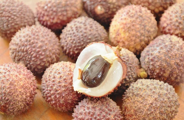 Lichi frutas tropicales pelar en tablero de madera —  Fotos de Stock