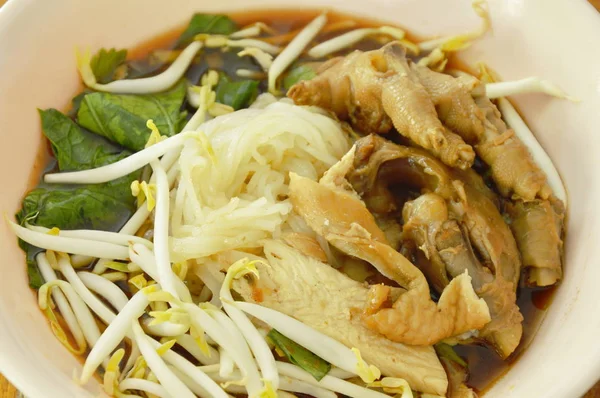 Cozido macarrão de arroz fino perna de frango e pés com broto de feijão em sopa marrom erva na tigela — Fotografia de Stock