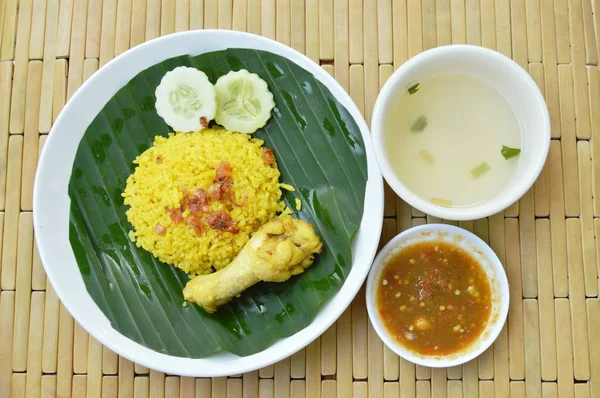 rice cooked with chicken in curry on plate and soup cup