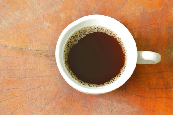 Czarny gorącej kawy w filiżance na drewnianym stole — Zdjęcie stockowe