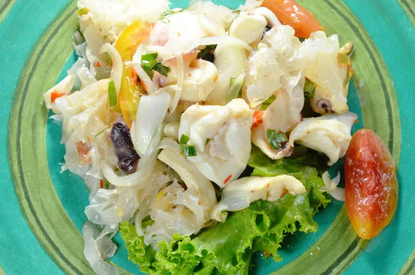 Тайский салат из кальмаров и свежие овощи на тарелке — стоковое фото