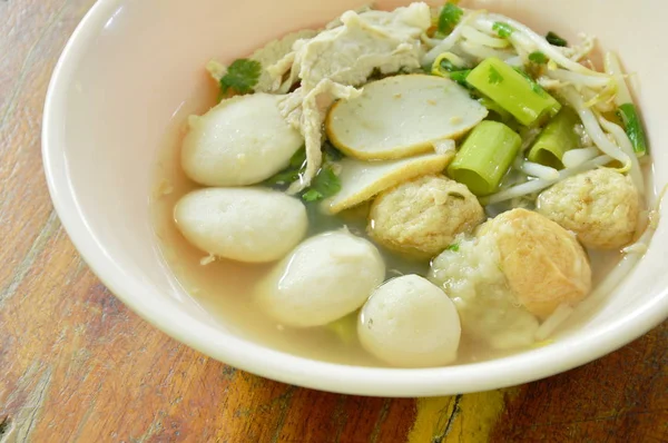Ikan rebus dan bola udang topping daging babi dalam sup jelas di mangkuk — Stok Foto