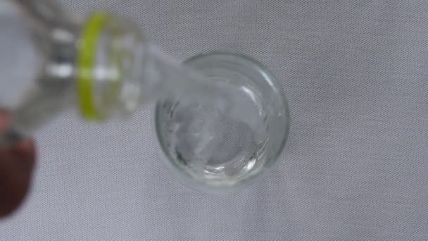 Вода Ллється Пляшки Питному Склі Білому Фоні — стокове відео