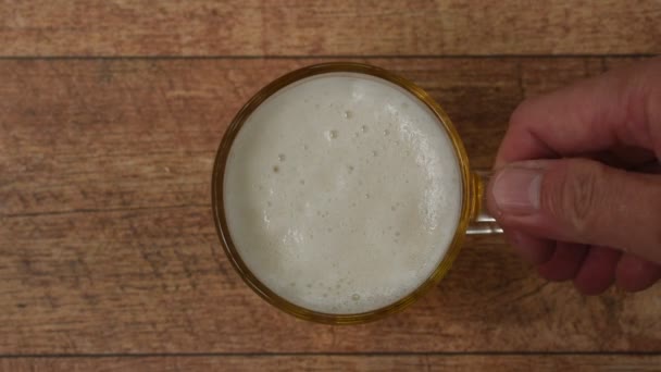 Hand Hält Kaltes Bier Mit Schaum Zum Trinken Und Legt — Stockvideo