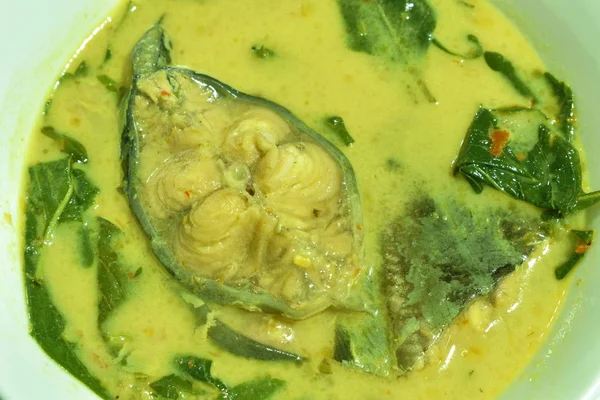 spicy boiled slice catfish with basil leaf in coconut milk and curry on bowl