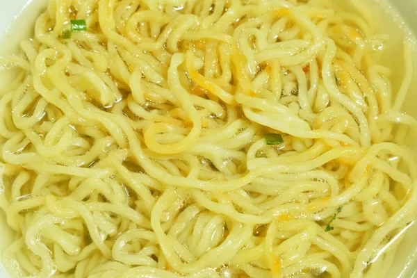 Close up de macarrão de ovo amarelo chinês em sopa clara na tigela — Fotografia de Stock