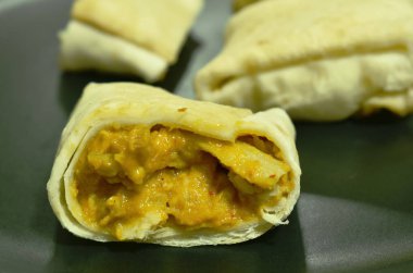 Roti doldurulmuş tavuk köri sosu tabakta kesiliyor.