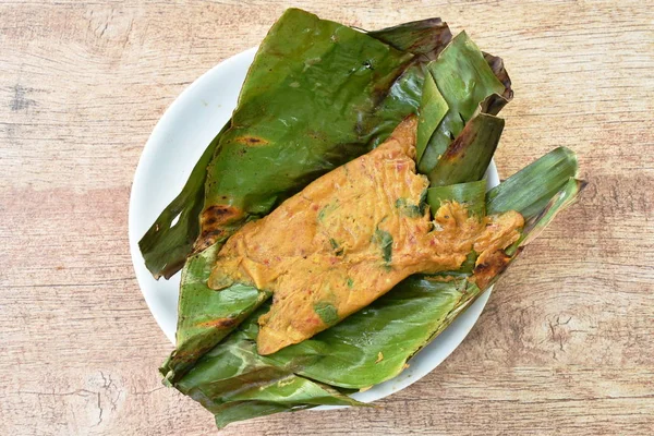 Ikan kari panggang dan kepiting tapal kuda telur yang dibungkus daun pisang — Stok Foto