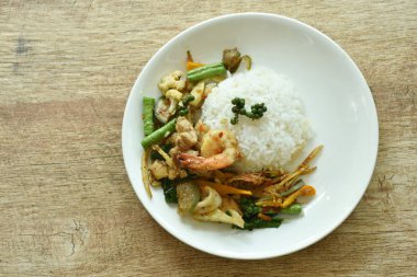  Baharatlı kızarmış deniz ürünleri ve acılı pilav.