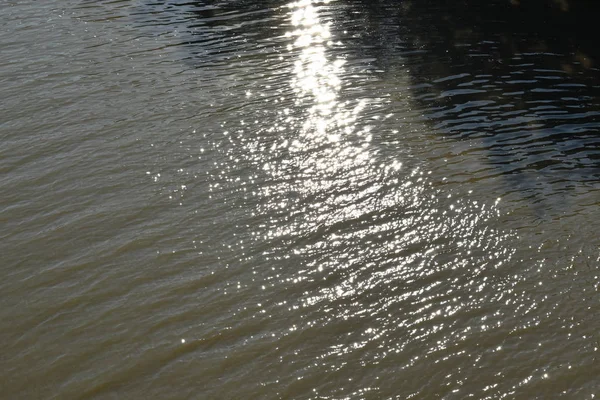 Reflexão da luz solar sobre a superfície da água no rio — Fotografia de Stock