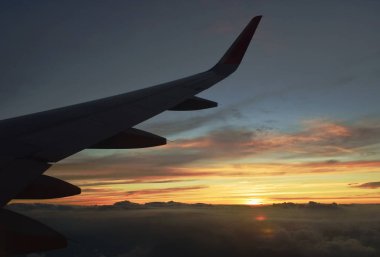  Gün batımında pencere çerçevesinde gökyüzünde yüzen kanat ve bulut