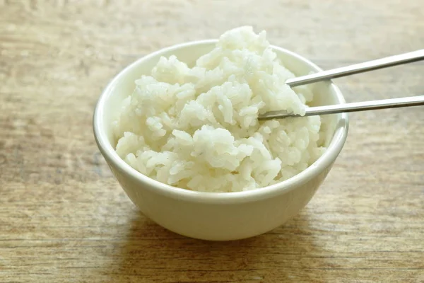 Pala de arroz llano en palillos de plata en la taza — Foto de Stock