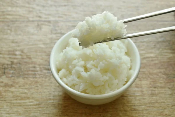 Απλό ρύζι μαζεύοντας σε ασημένια chopticks στο κύπελλο — Φωτογραφία Αρχείου