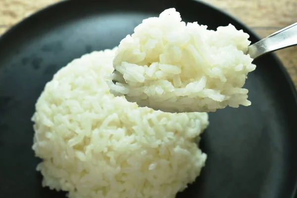 Sima rizs lapátolás ezüst kanállal tányéron — Stock Fotó