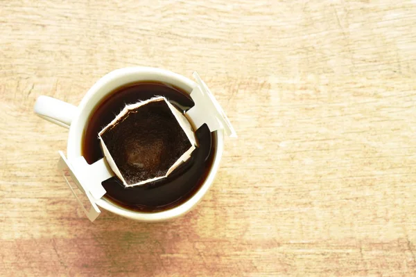 Polvo de goteo de café caliente con filtro en taza en la mesa — Foto de Stock