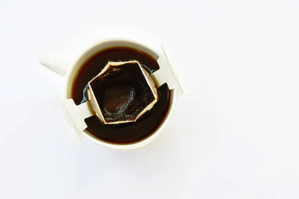 Polvere di caffè caldo goccia con filtro in tazza su sfondo bianco — Foto Stock