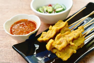  pork satay with sweet peanut sauce and pickled vegetable cup