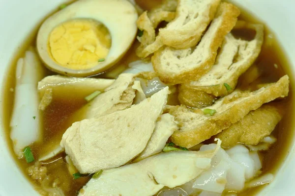 中国の米粉をスライスチキンと揚げ豆腐の上の卵と茶色のスープに貼り付ける — ストック写真