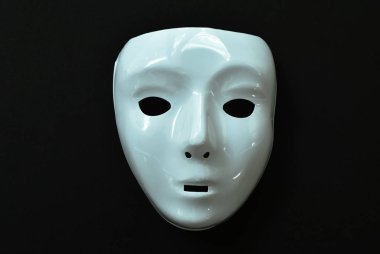  Siyah kumaş arka planda beyaz plastik insan yüzü maskesi