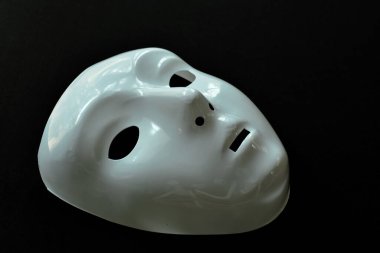  Siyah kumaş arka planda beyaz plastik insan yüzü maskesi