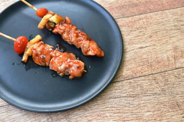  Ananaslı kızarmış tavuk ve domates soslu barbekü tabağa tahta sopa saplıyor.