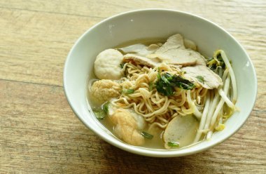  Haşlanmış sarı hazır şehriye dilimlenmiş domuz eti ve top berrak çorba kasesinde.