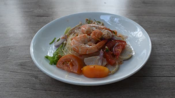配虾的玻璃面和切碎的猪肉辣沙拉放在盘子里 用银叉刺着吃 — 图库视频影像