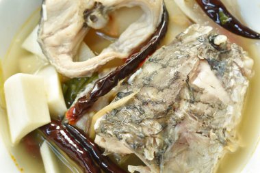  Baharatlı haşlanmış yılan başı balığı ve hindistan cevizi dilimi kasede Tom yum çorbası.