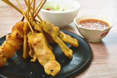  pork satay with sweet peanut sauce and pickled vegetable cup
