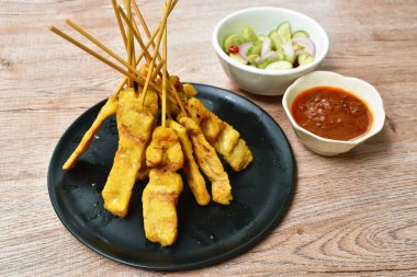  pork satay with sweet peanut sauce and pickled vegetable cup