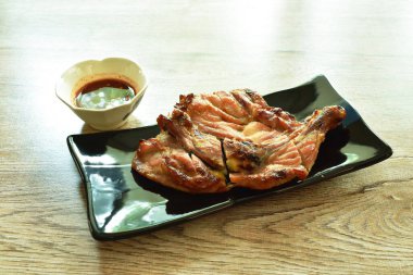 Izgara tavuk kalçası ve tabakta bacağı baharatlı tamarind sosuyla soslanmış.