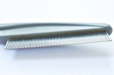  Beyaz arka planda köpek ve kediye kene ya da pire yakalamak için kırmızı kauçuk saplı ince diş tarağı