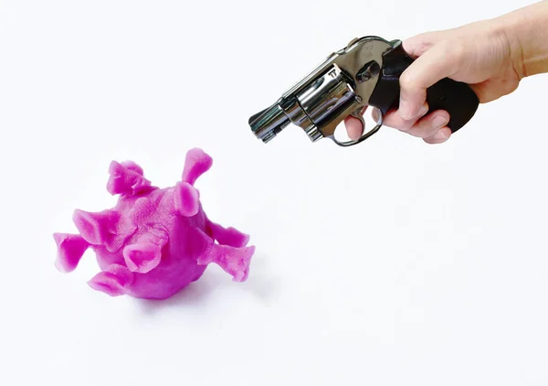 紫色のコロナウイルスやCovid 19の彫刻を白い背景に粘土で撮影する準備をする手押しの回転銃 — ストック写真
