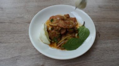 Çatal saplı pilav ve baharatlı domuz etli Tayland salatası taze fesleğen yaprağı ve lahana ile yenir.
