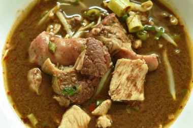 Kavanozda pişmiş domuz eti ve fasulye filizi ile kahverengi çorba.