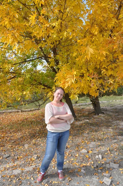 Una donna è in piedi in una foresta autunnale — Foto Stock