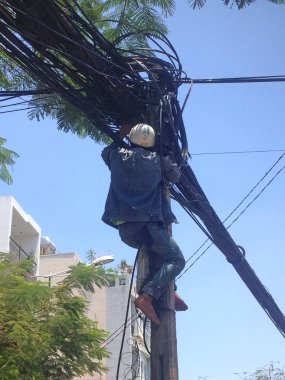 Elektrikçi tırmanma direkleri, güç hatları tamir. Vietnam