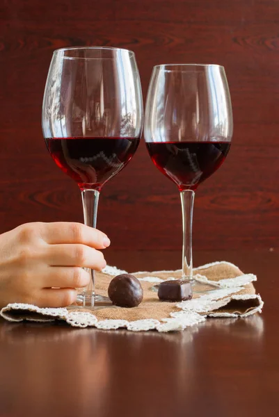 Zwei Gläser Wein auf einem Holztisch. Süßigkeiten. Hände. — Stockfoto