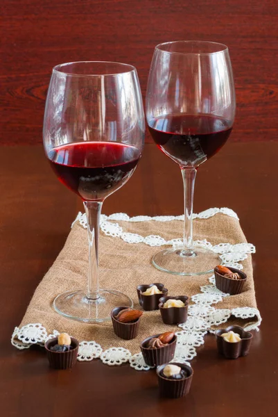 Zwei Gläser Wein auf einem Holztisch. Bonbons. — Stockfoto