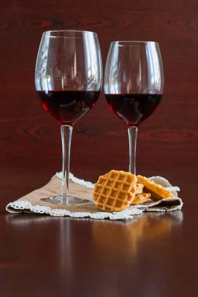 Zwei Gläser Wein auf einem Holztisch. Waffeln. — Stockfoto