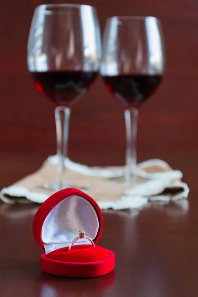 Deux verres de vin sur une table en bois. Boîte rouge avec bague de fiançailles — Photo