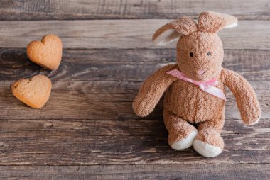 Kalp şeklinde kurabiye ile kabarık oyuncak tavşan. Kartpostal 