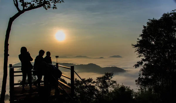 Silhouetten von Touristen auf einem Aussichtspunkt mit dem Berg am Morgen — Stockfoto
