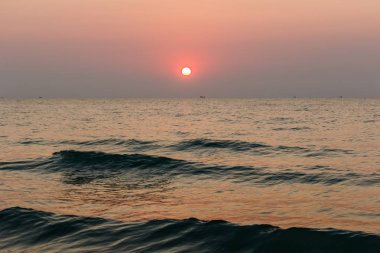 Beach günbatımı kıyıya inişli çıkışlı bir dalga ile altın bir günbatımı gökyüzü olduğunu