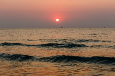 Beach günbatımı kıyıya inişli çıkışlı bir dalga ile altın bir günbatımı gökyüzü olduğunu