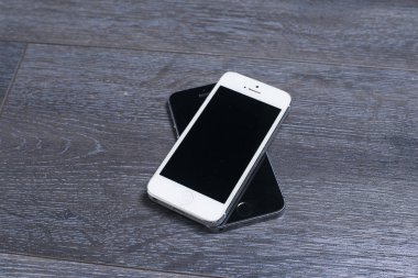 Farklı renkte iki telefon: siyah ve beyaz..