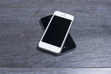 Farklı renkte iki telefon: siyah ve beyaz..